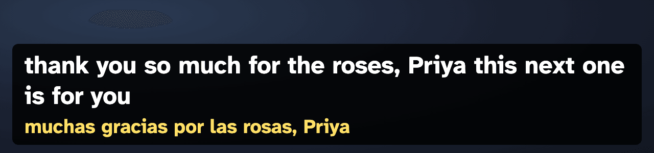 Screenshot of the live captions overlay over a dark stream background. Large white words on a black box read: thank you so much for the roses, Priya this next one is for you. Underneath, in yellow, the Spanish translation: muchas gracias por las rosas, Priya.